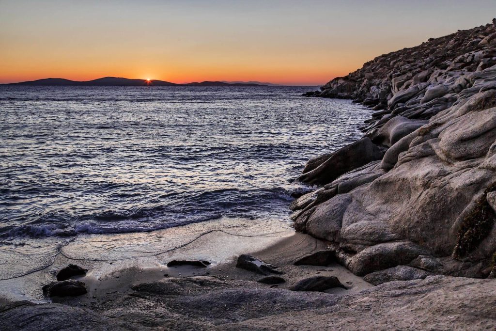 view of a sunset from a rocky beach