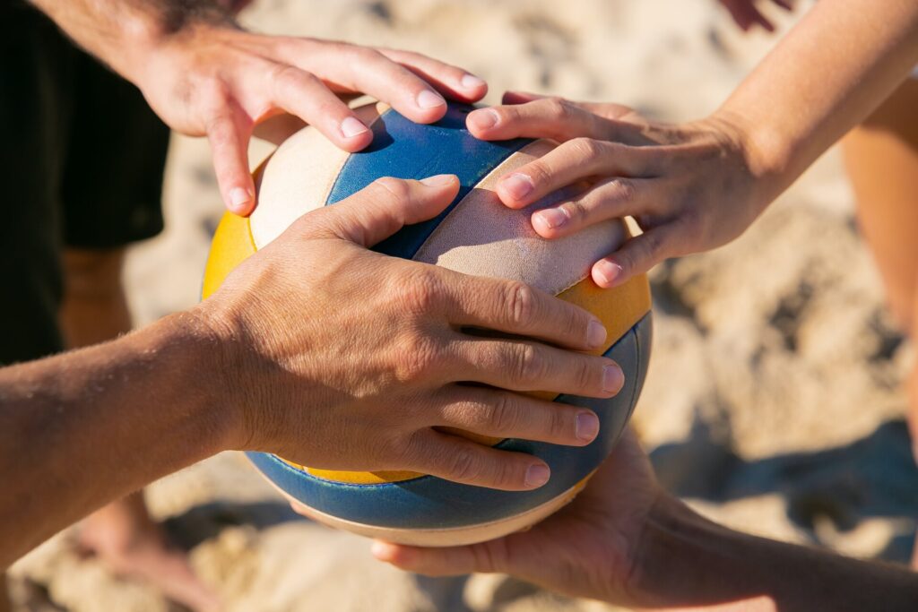 People holding a hand on a ball